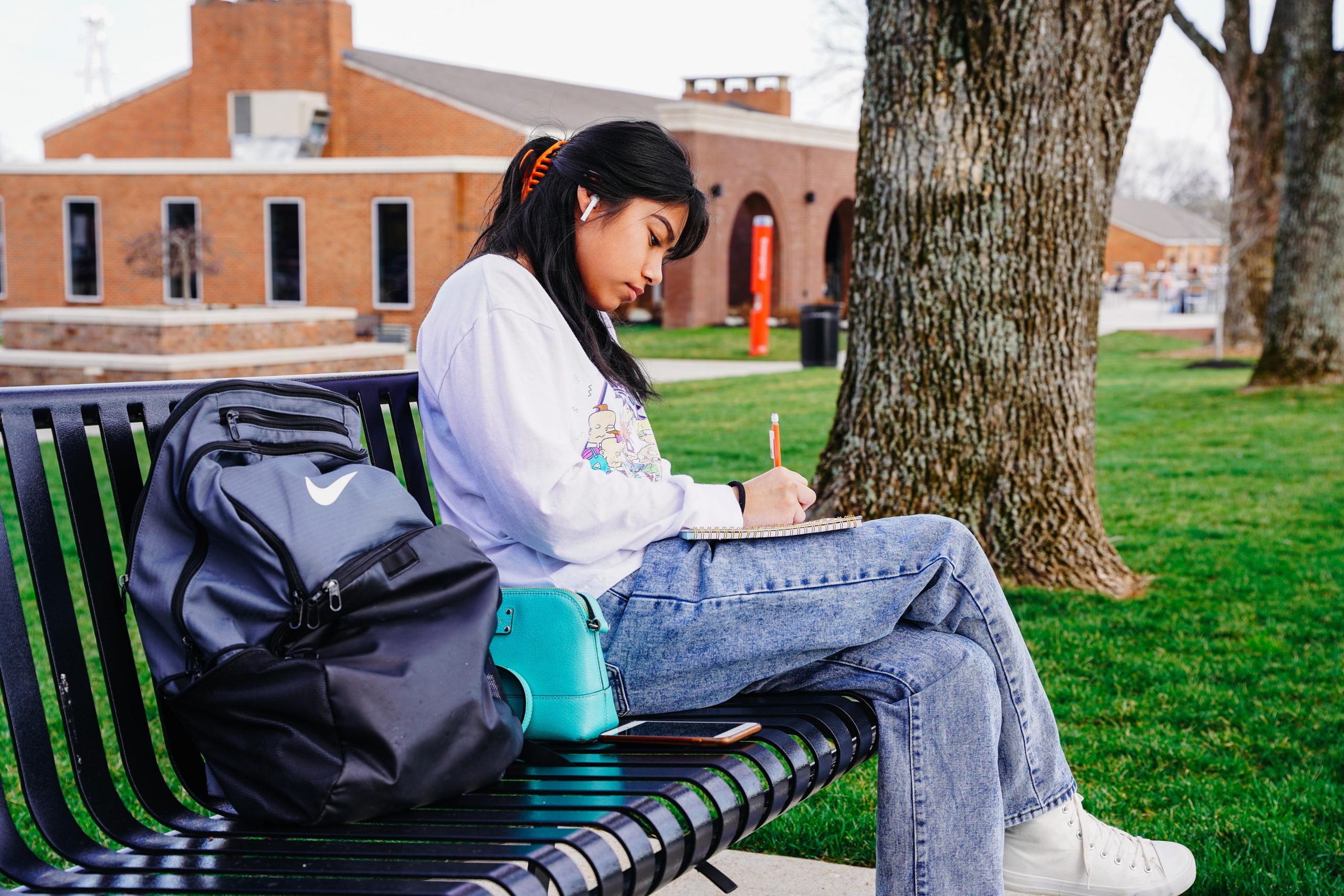 Student sitting on bench and writing